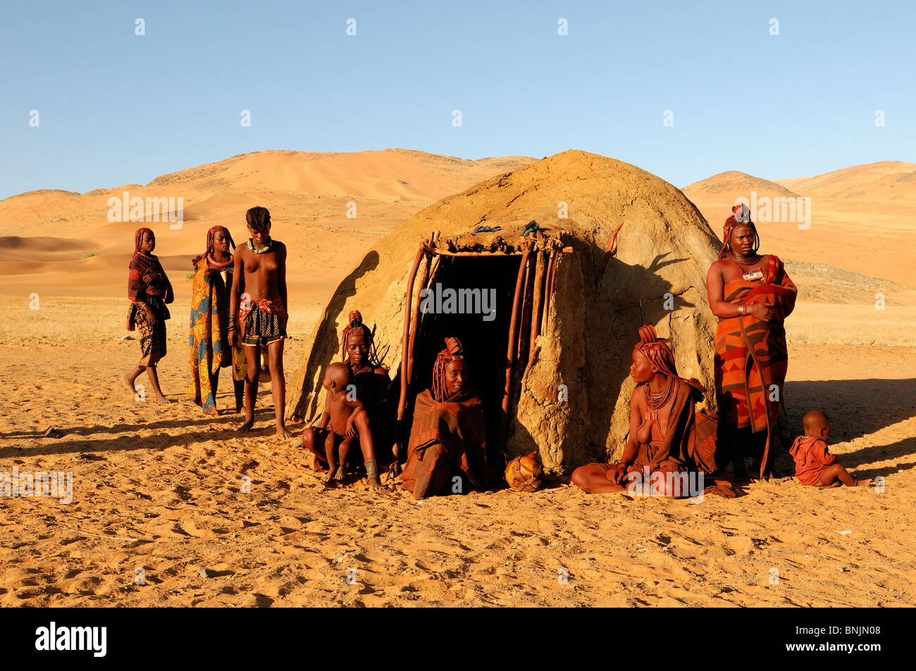 Les femmes Himba hut village Serra Cafema Kunene River Wilderness Safaris Région Kunene Namibie Afrique Voyage Nature famille desert Banque D'Images