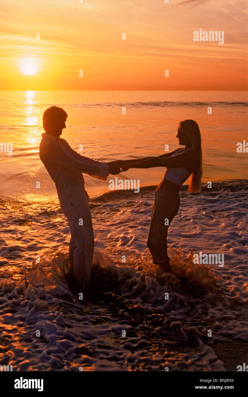 Couple jouant sur la côte de sable au coucher du soleil à Laguna Beach en Californie USA Banque D'Images
