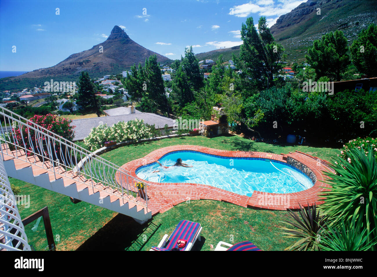 Femme en piscine résidentielle en vertu de la tête de lion mountain à Camps Bay à Cape Town Afrique du Sud Banque D'Images