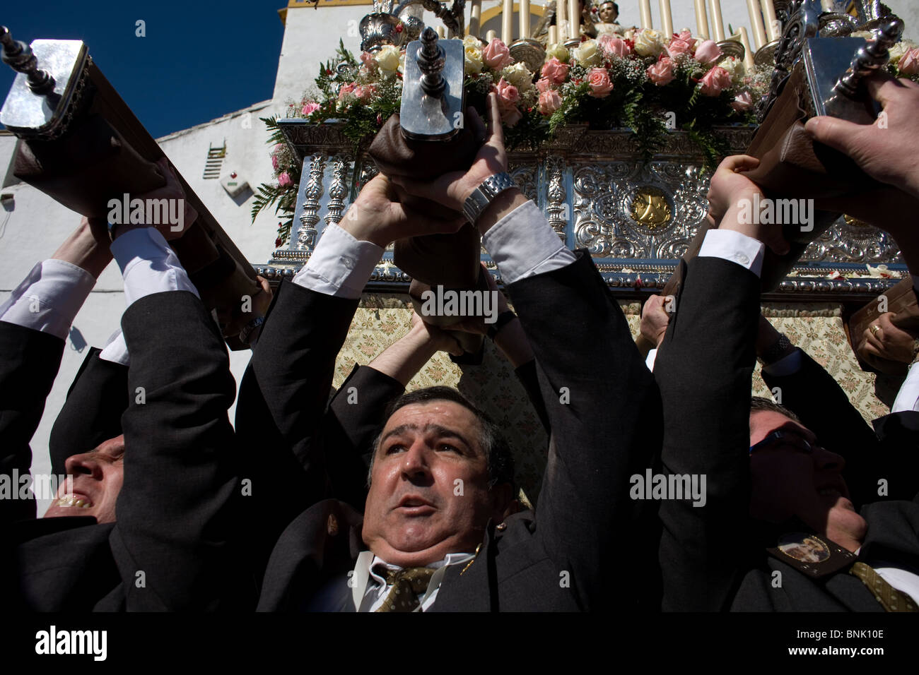 Ascenseur hommes transportant une lourde trône la Vierge de Carmen lors d'une procession de la Semaine Sainte de Pâques en Prado del Rey, Andalousie, Espagne Banque D'Images