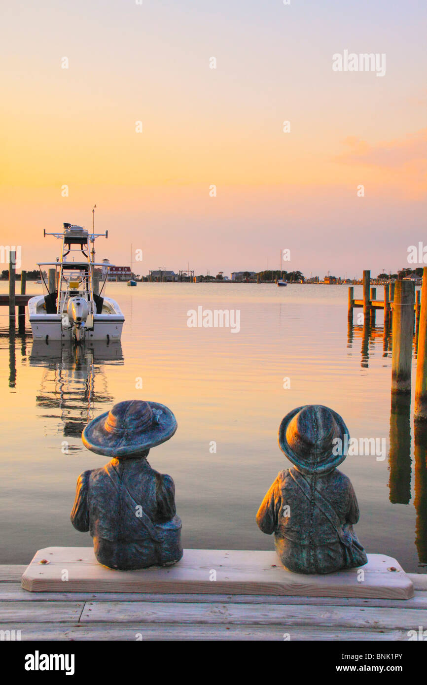 Statues de l'enfant sur un quai au coucher du soleil, Silver Lake Harbour, Ocracoke Island, Cape Hatteras National Seashore, North Carolina, USA Banque D'Images