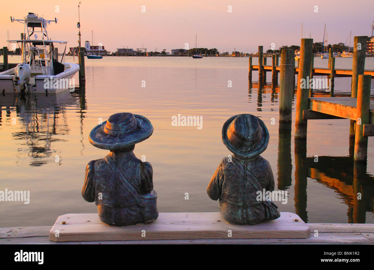 Statues de l'enfant sur un quai au coucher du soleil, Silver Lake Harbour, Ocracoke Island, Cape Hatteras National Seashore, North Carolina, USA Banque D'Images