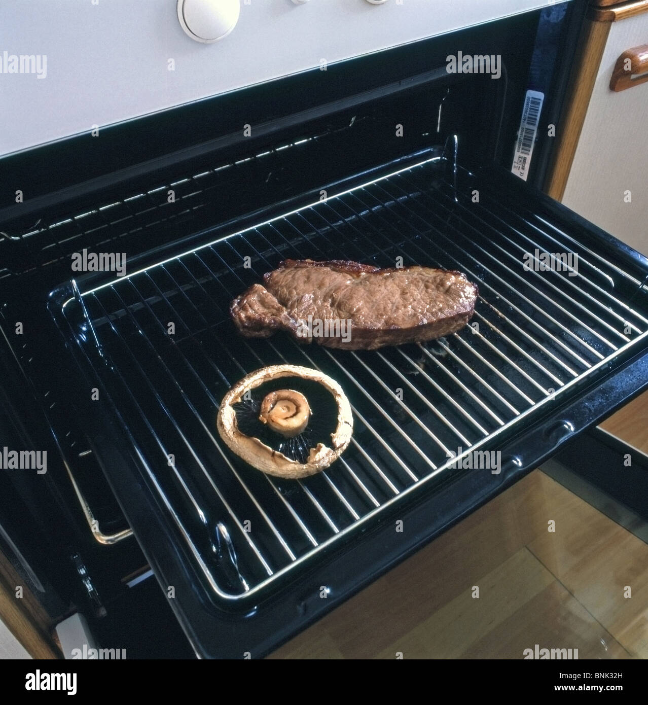 Steak de surlonge cuit et Flat Mushroom sur un gril prises sous un four grill dans un cadre domestique Banque D'Images