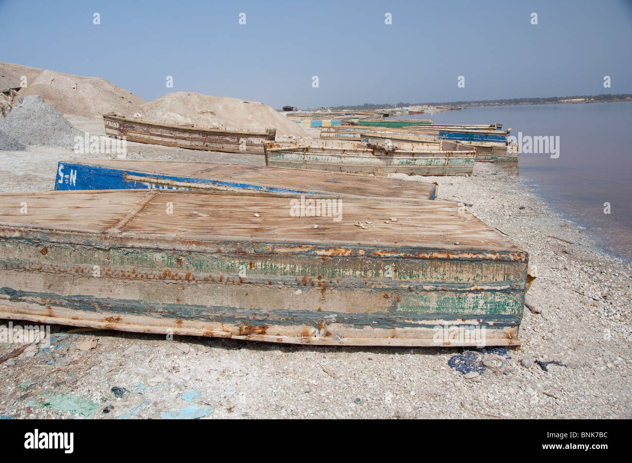 Afrique, Sénégal, Dakar. Le Lac Rose de Retba. La récolte de sel bateaux le long de la rive du lac saumâtre. Banque D'Images