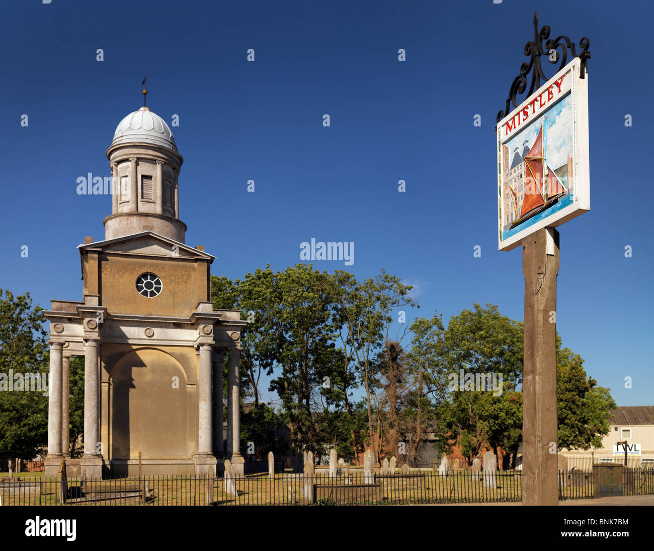 Mstley panneau du village avec l'une des tours jumelles qui faisaient autrefois partie de l'ancienne église néo-classique visible Banque D'Images