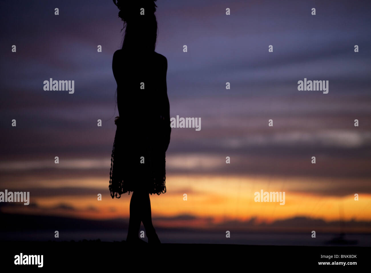 La silhouette de danseuse de hula contre coucher du soleil Banque D'Images