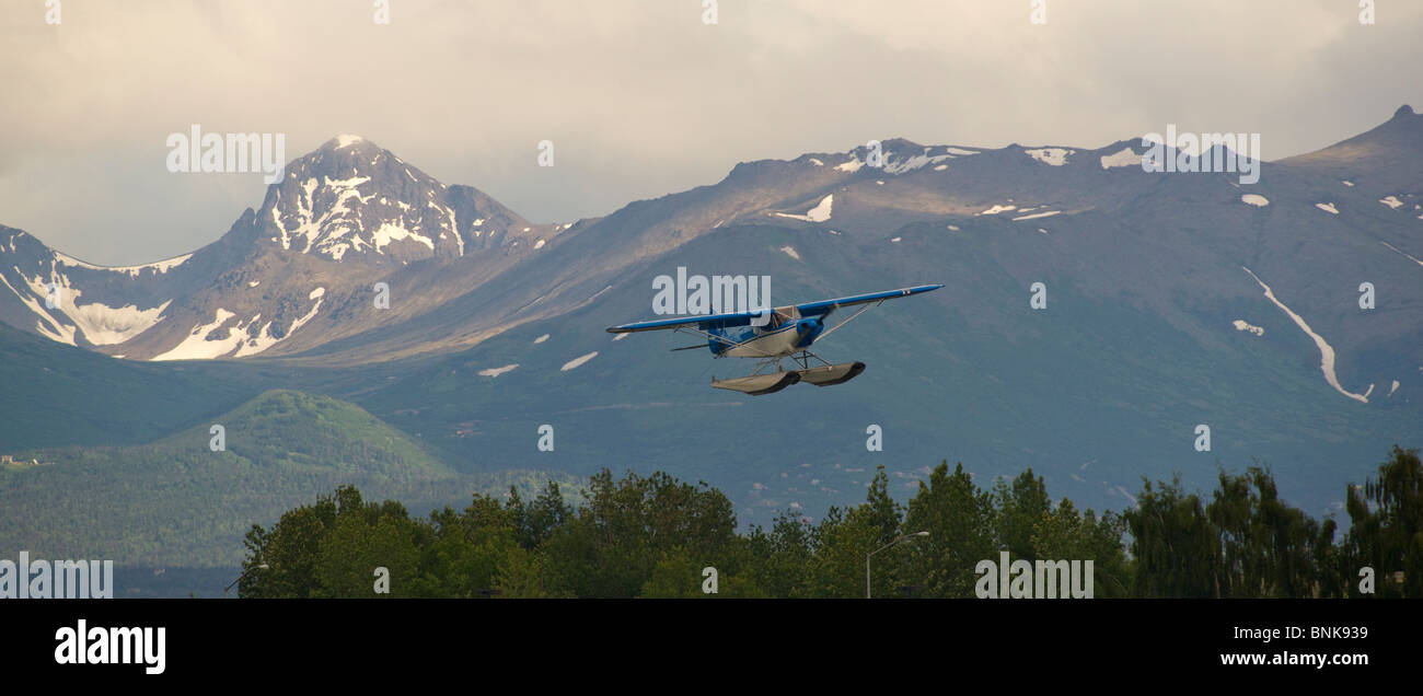 Avion ponton vole de Lake Hood à Anchorage, encadré par les montagnes Chugach Banque D'Images