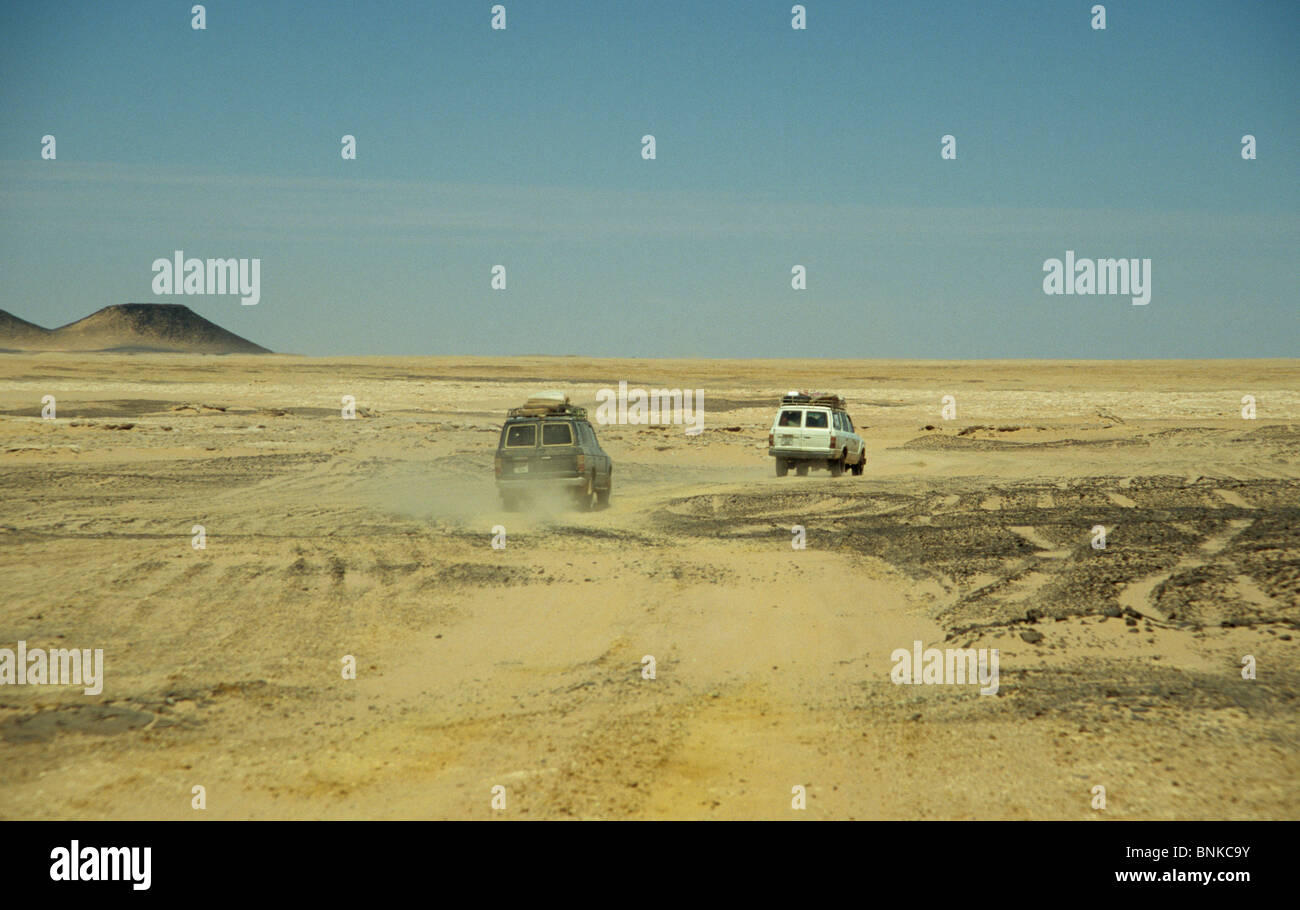 Voitures 4X4 roulant sur une mauvaise voie à travers le désert du Sahara, la Libye Banque D'Images