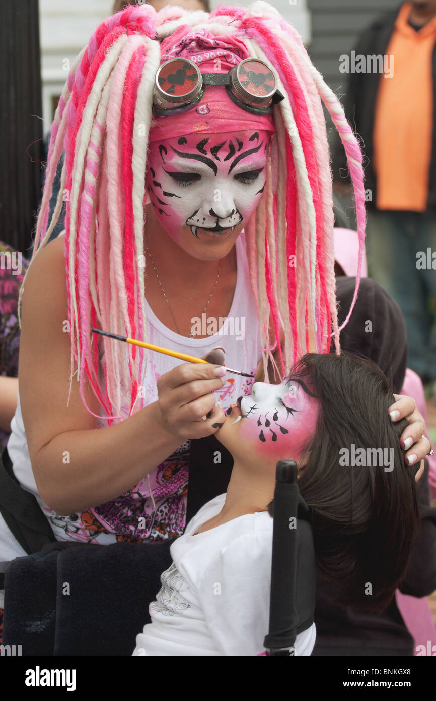 Une jeune fille ayant son visage peint par une femme artiste au festival Long Grove, États-Unis Banque D'Images