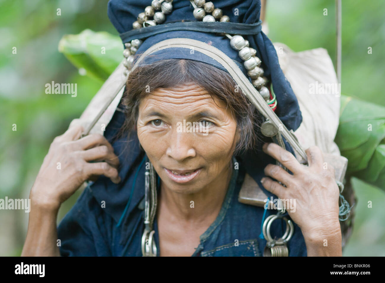 Un carnying femme Akha attrape un panier sur son dos sur un sentier dans le Nord du Laos Banque D'Images