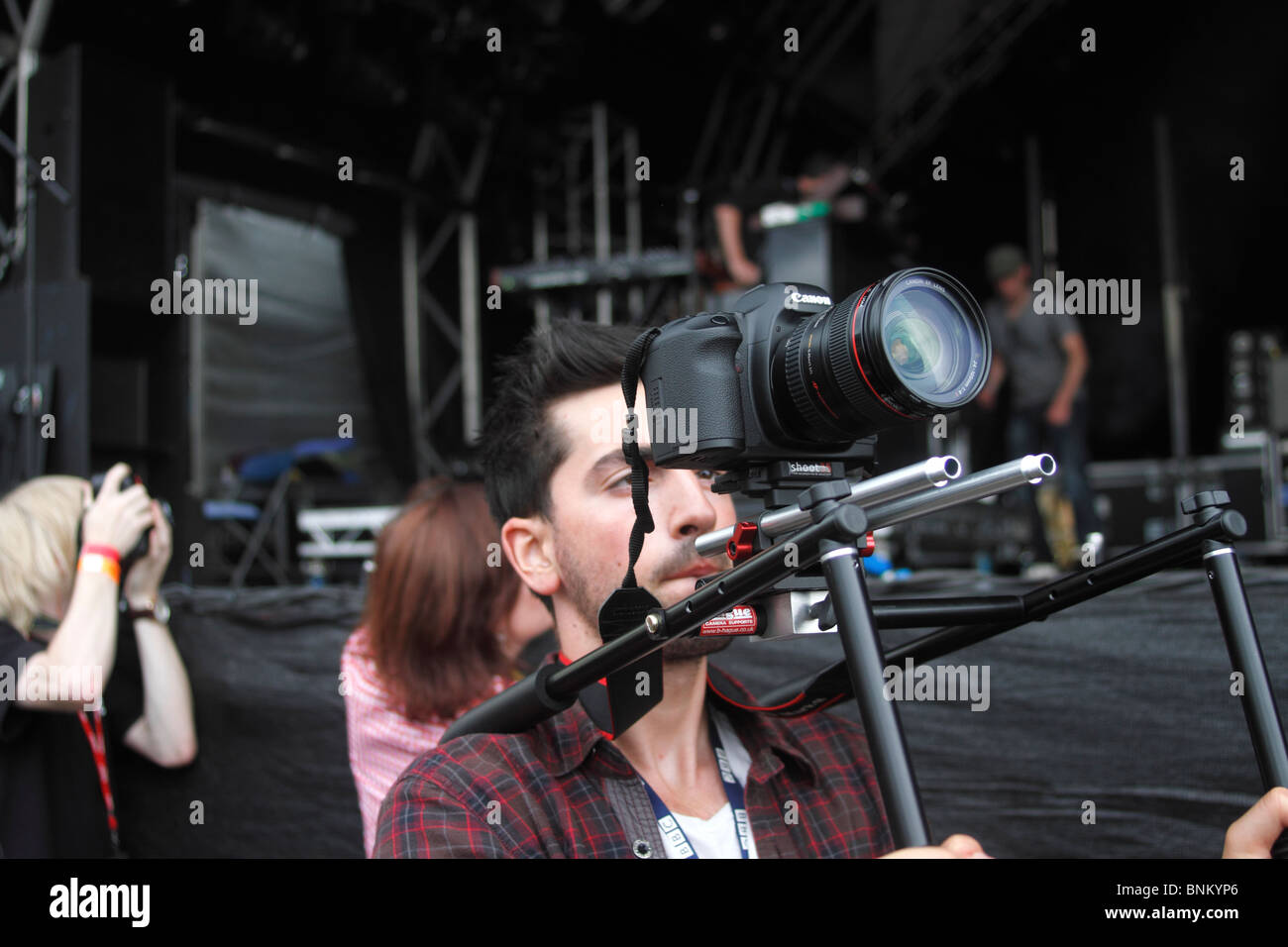 Cet homme a été le tournage d'images en mouvement à l'aide de la tige35 soutien et un Canon 5D et un Canon 24-105mm la splendeur Festival à Nottingham Wollaton Park. Banque D'Images