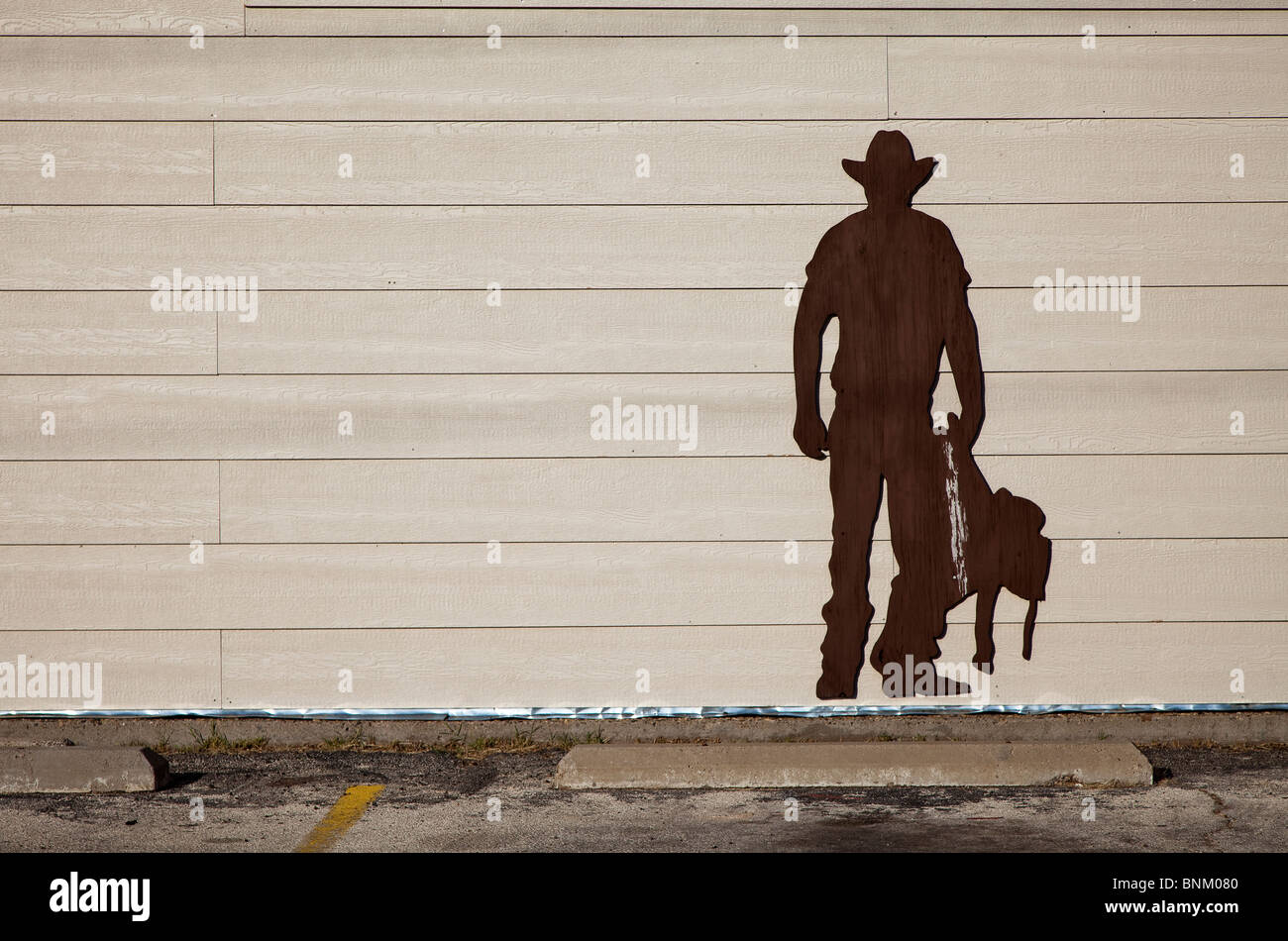 Silhouette en bois de découpe cowboy sur mur bâtiment Kermit Texas USA Banque D'Images