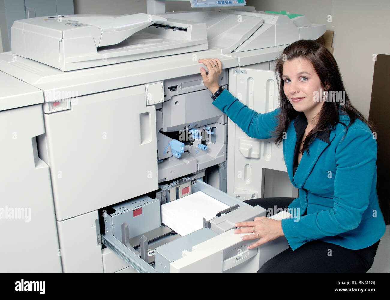 Jeune femme contrôle le document dans une photocopieuse Photo Stock - Alamy