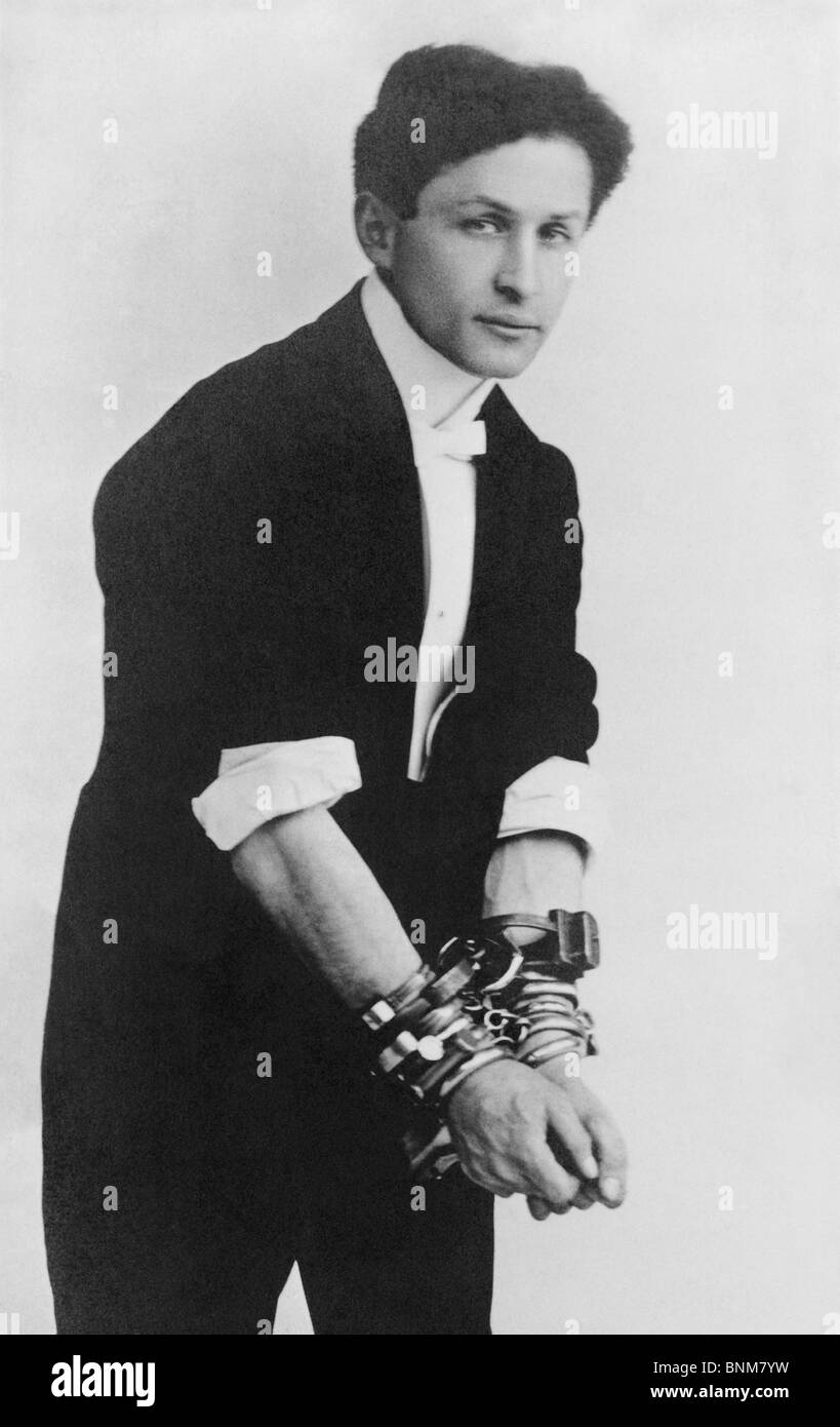 Portrait photo vers 1905 de magicien et de l'évasion Harry Houdini (1874 - 1926) de porter plusieurs paires de menottes. Banque D'Images
