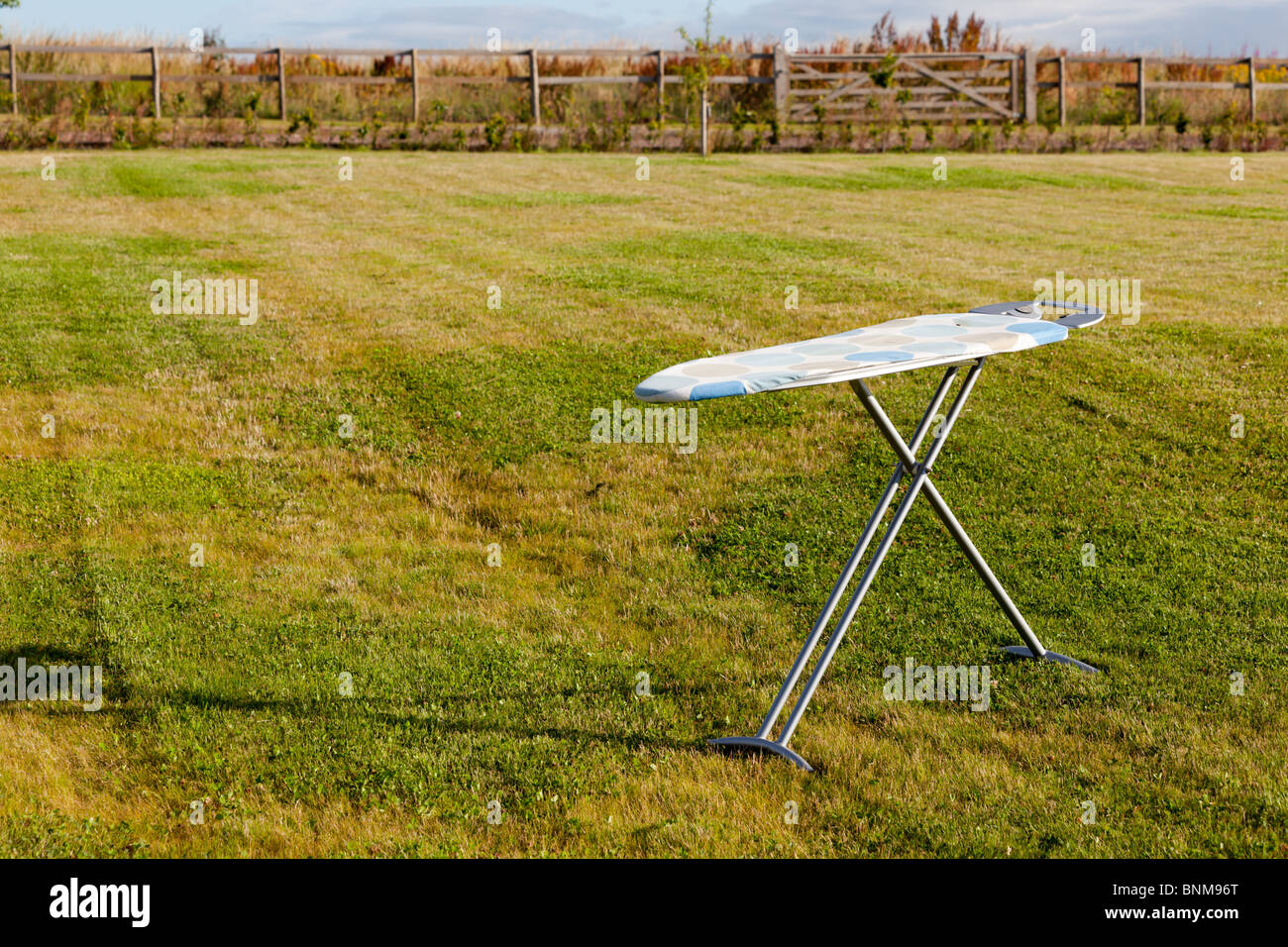 Une planche à repasser à l'extérieur sur une pelouse sous un ciel orageux Banque D'Images