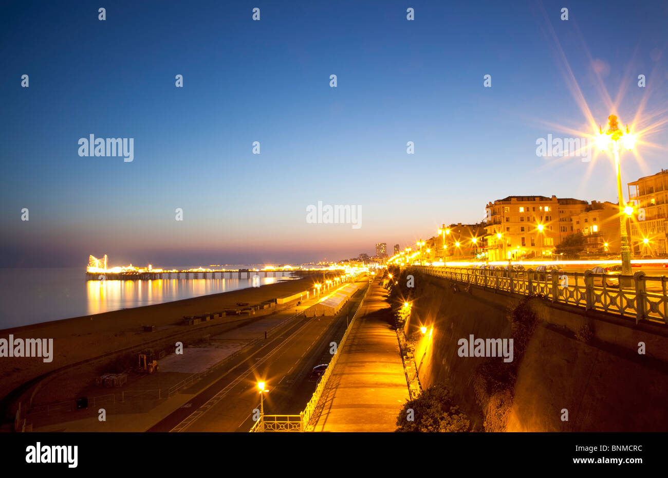 L'Angleterre, l'East Sussex, Brighton, Kemptown, vue sur Madère Route de Marine Parade avec l'embarcadère allumé au coucher du soleil. Banque D'Images