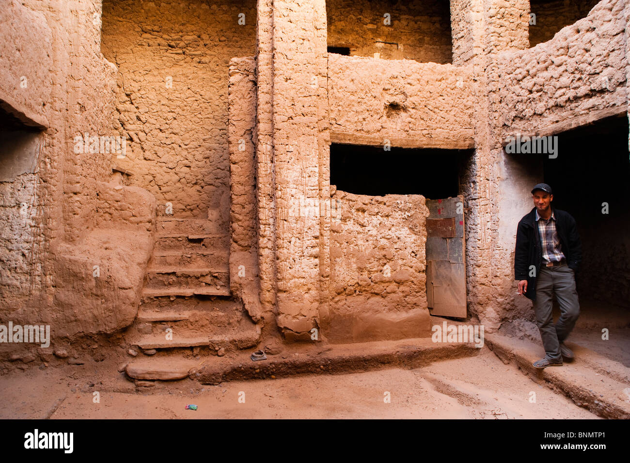 Ouvrier marocain dans un patio, bâtiment traditionnel en brique de boue, Figuig, province de Figuig, région orientale, le Maroc. Banque D'Images