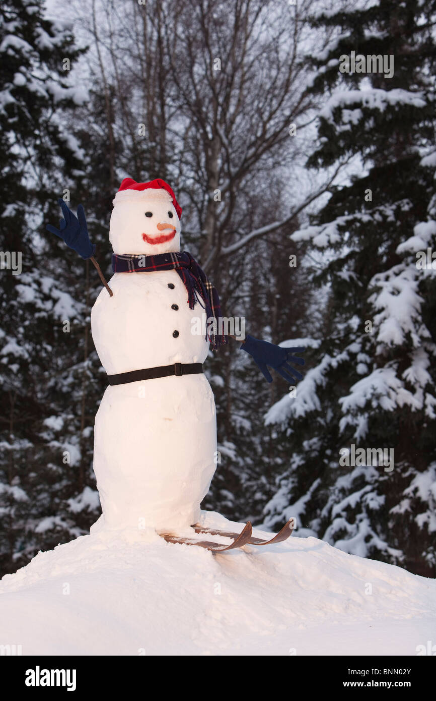 Un bonhomme équipé d'un chapeau de Père Noël, des gants et des skis est perché sur une petite colline couverte de neige à Anchorage, Alaska Banque D'Images