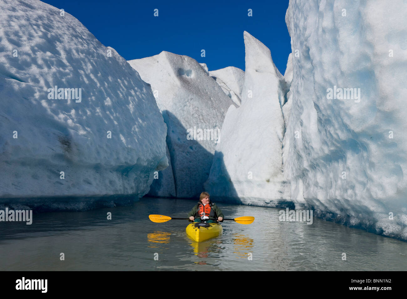 Un kayakiste de pagaies et explore les séracs du glacier de Mendenhall sur un matin d'automne, de l'Alaska Banque D'Images