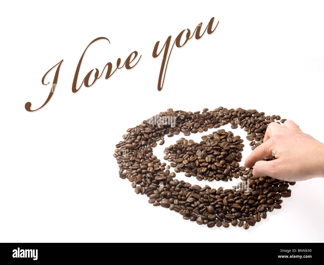 Part de la conception d'un coeur avec des grains de café, comme un symbole de l'amour. La photographie a des ombres, mais le texte est sur du whi Banque D'Images
