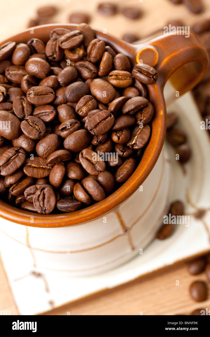 Les grains de café dans la tasse en céramique Banque D'Images