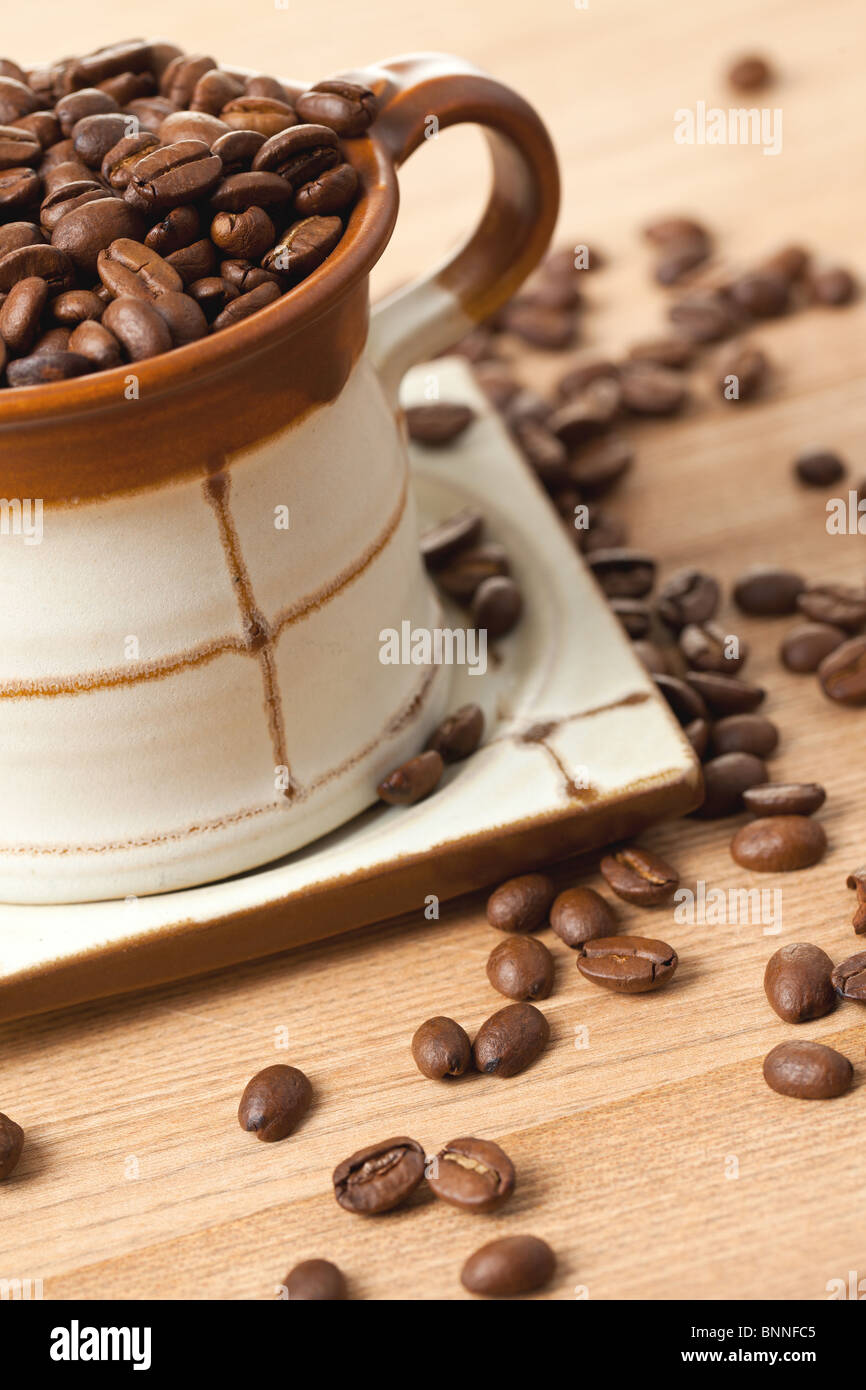 Les grains de café dans la tasse en céramique Banque D'Images