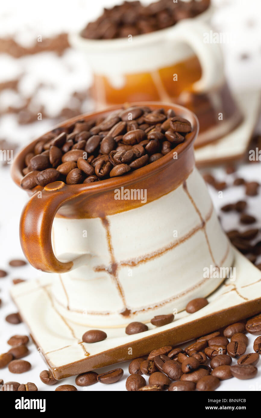 Les grains de café dans la tasse en céramique Banque D'Images