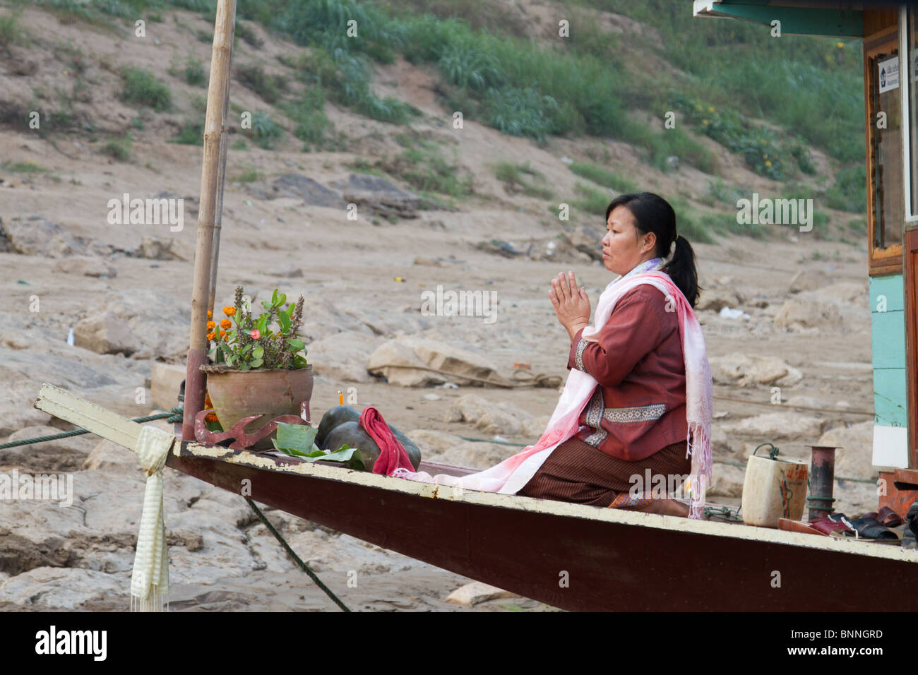 Les femmes laotiennes priant sur la proue d'un bateau Banque D'Images