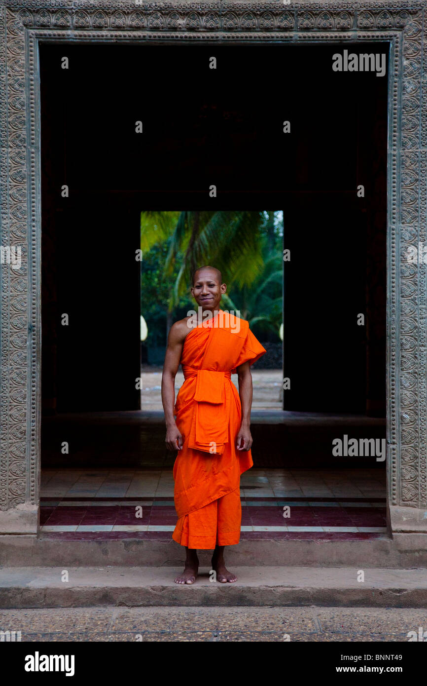 Moine novice de poser dans le cadre de la porte d'un wat - Province de Kandal, Cambodge Banque D'Images