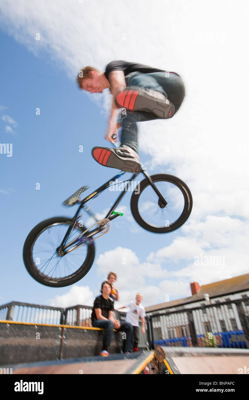 Adolescents effectuer les acrobaties sur vélos BMX à un BMX Park à Rhyl, au nord du Pays de Galles. Banque D'Images