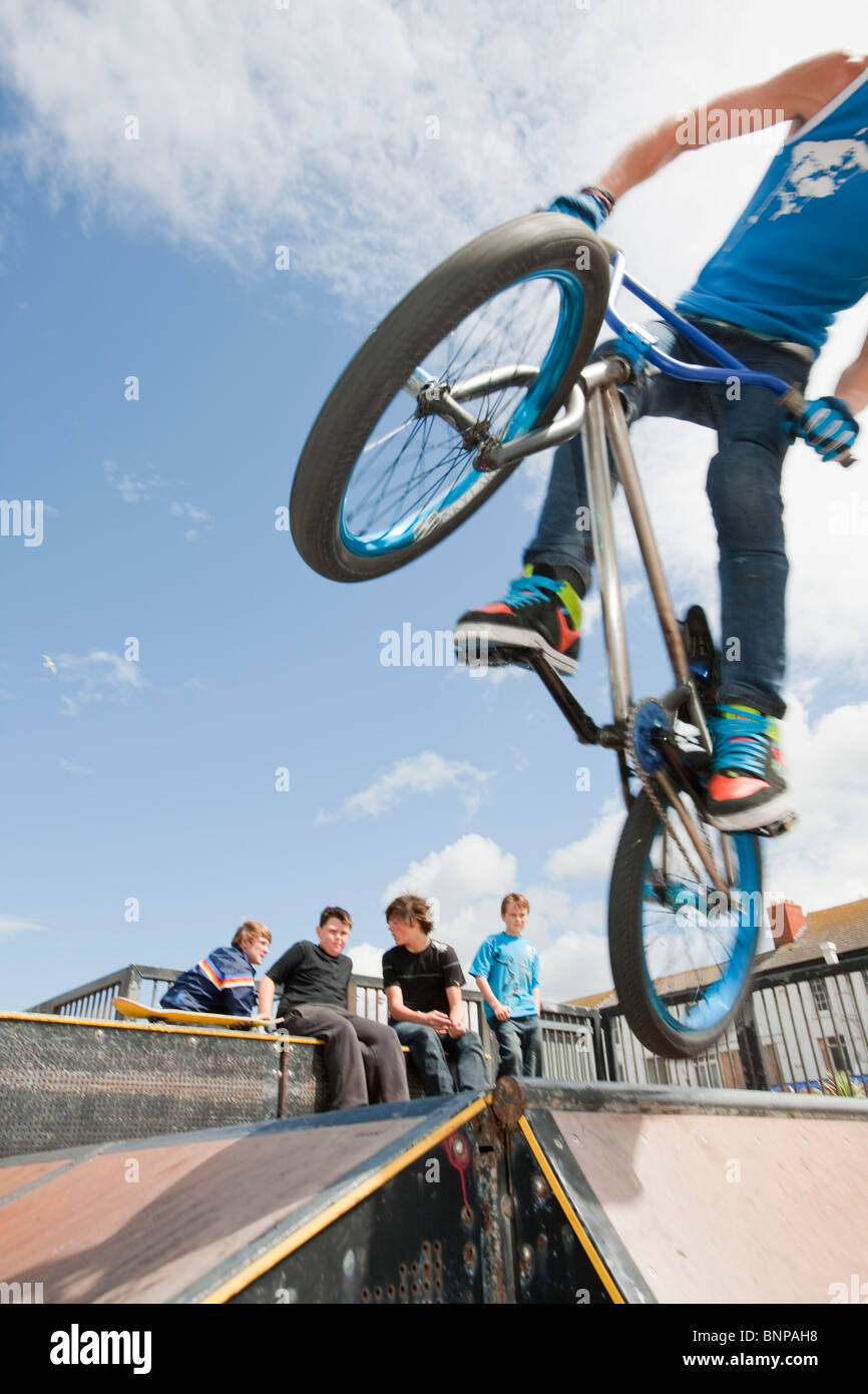 Adolescents effectuer les acrobaties sur vélos BMX à un BMX Park à Rhyl, au nord du Pays de Galles. Banque D'Images