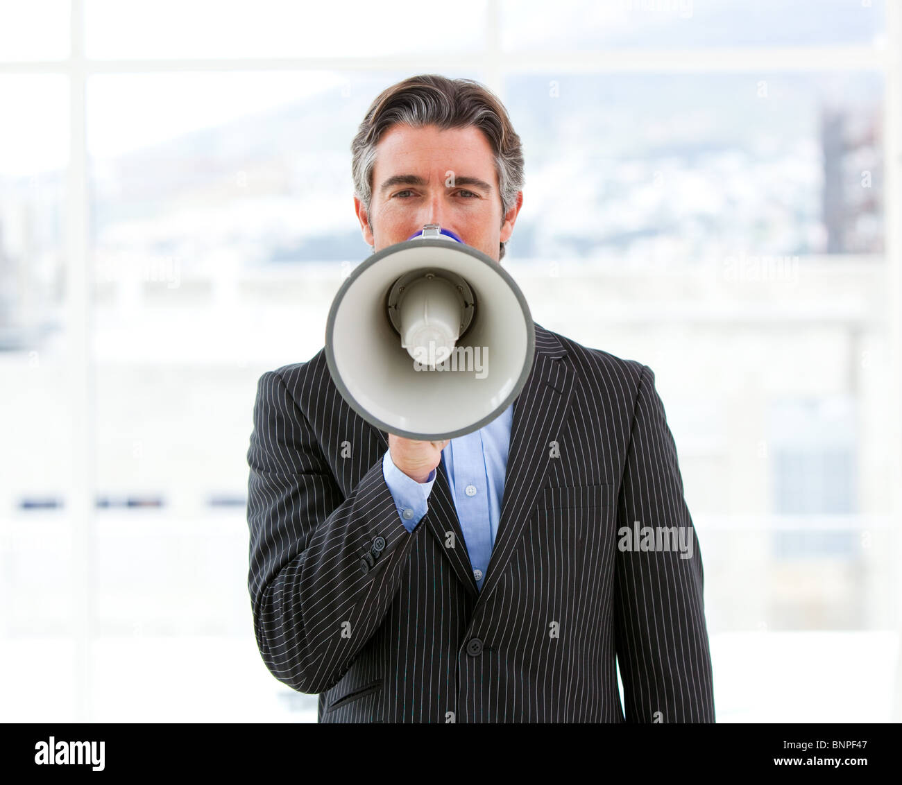 Mature businessman yelling through a megaphone Banque D'Images