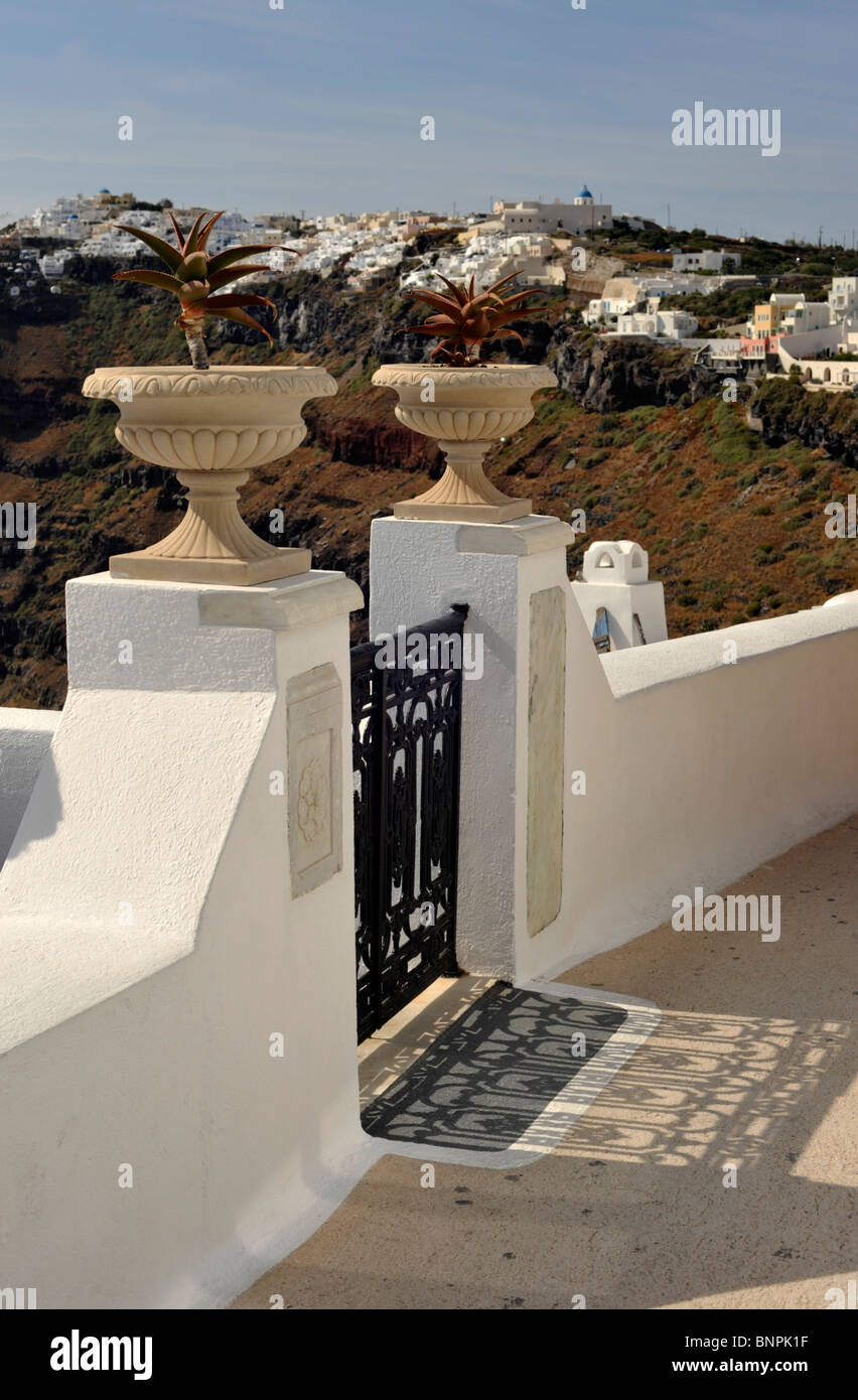 2 urnes d'autre d'une porte en fer forgé menant à une villa à Santorin en Firostfani les Cyclades Grèce Banque D'Images