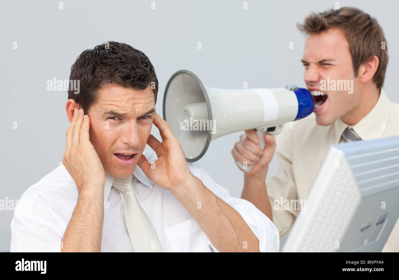 Businessman yelling avec un porte-voix à son collègue Banque D'Images