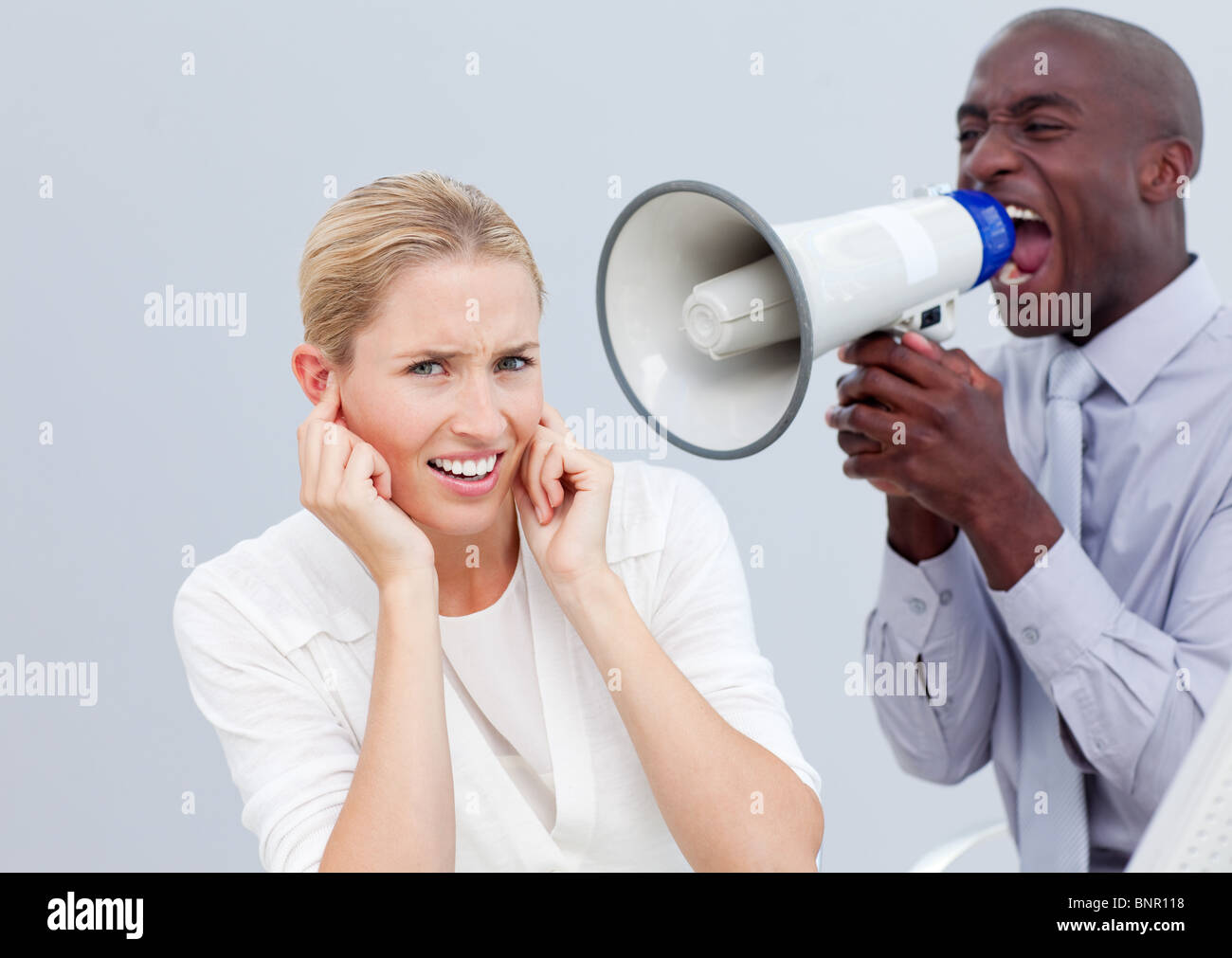 Angry businessman shouting through a megaphone Banque D'Images