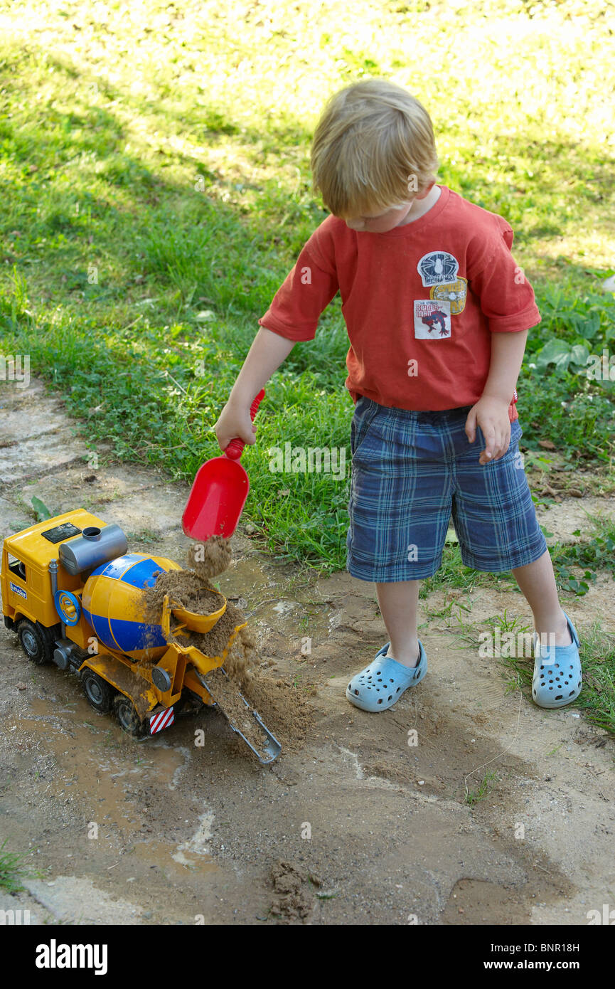 Garçon enfant à sable en jouant avec leur nom et les jouets voiture voitures  véhicule jeux 2 3 4 ans Photo Stock - Alamy
