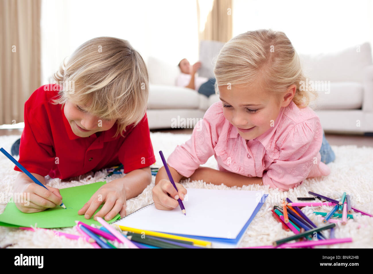 Dessin enfants concentré se trouvant sur le plancher Banque D'Images