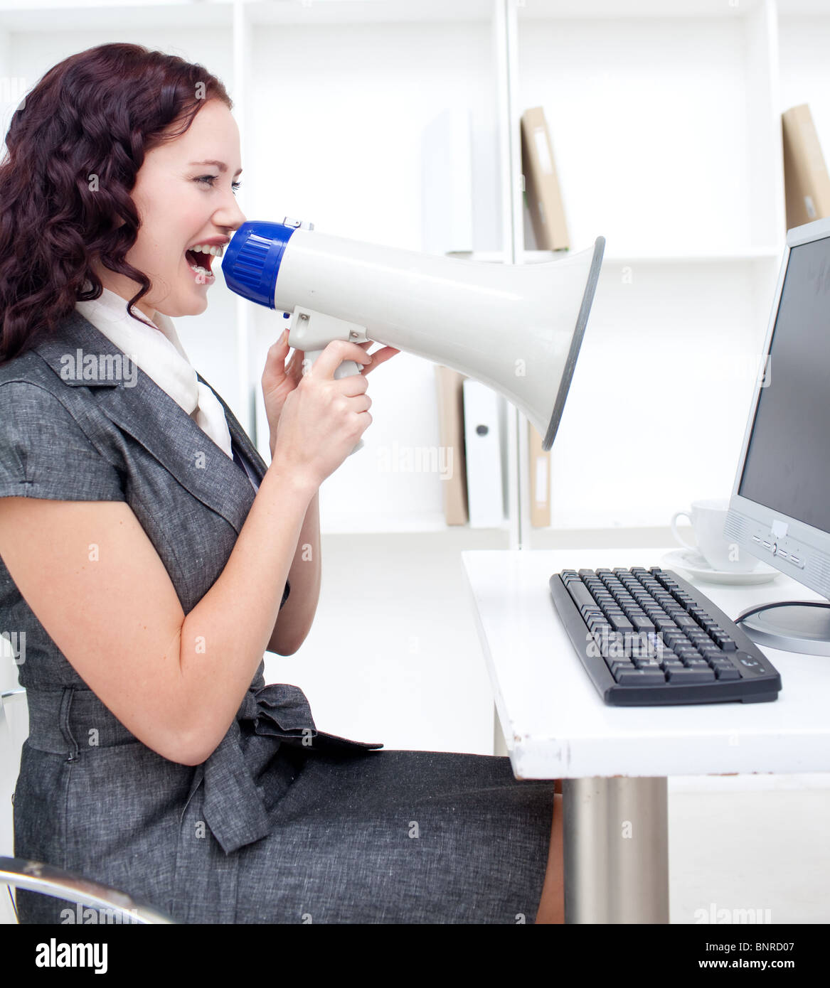 Businesswoman yelling through a megaphone Banque D'Images