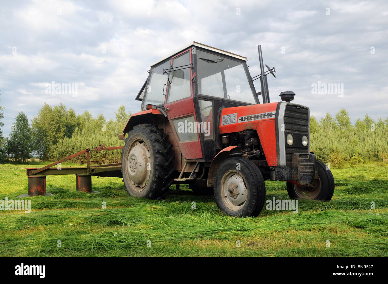 La fenaison sur campagne, Pologne. Polish ursus 3512 tracteur avec les faucheuses rotatives (également appelé tondeuses à tambour) Banque D'Images
