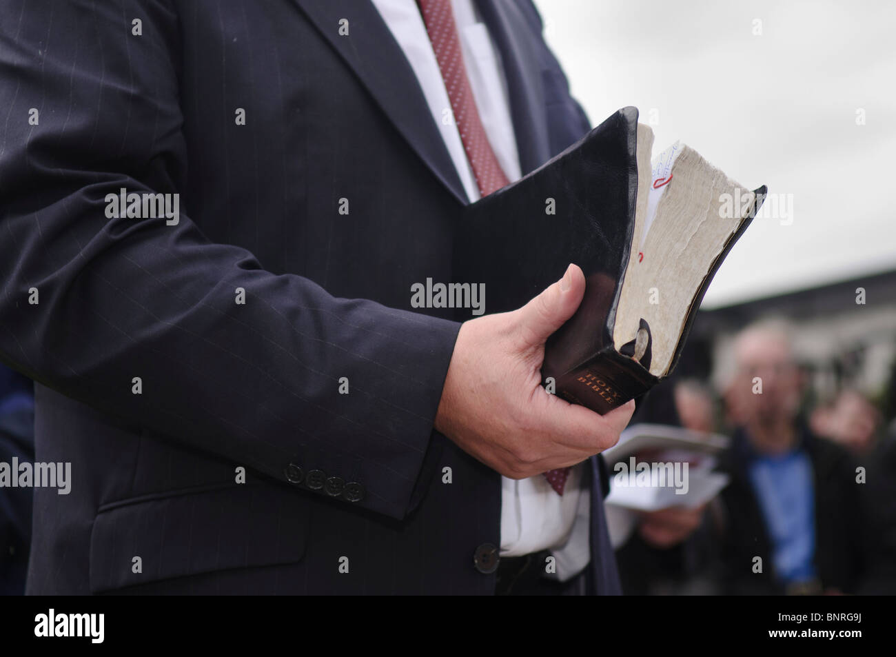 Ministre la tenue d'une grande, bien utilisé bible Banque D'Images