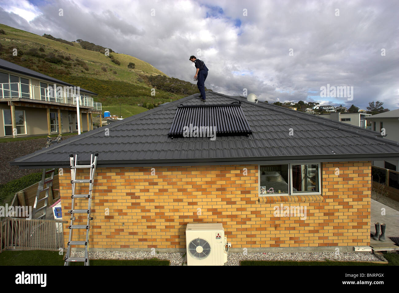 Artisan qualifié l'installation de chauffe-eau solaire pour une maison, Nelson, Nouvelle-Zélande, la ville ayant le plus grand ensoleillement Banque D'Images