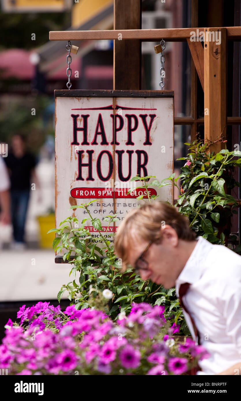 Un employé de bureau masculins de détente à une table à l'extérieur d'un bar de New York au cours d'une pause déjeuner à Greenwich Village, Manhattan, New York, USA Banque D'Images