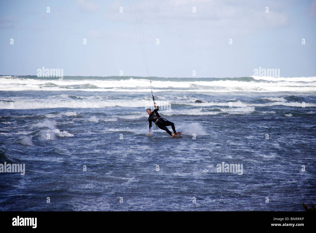 Kitesurfer mâle change de direction et touche l'eau comme il tourne. Banque D'Images Kitesurfer mâle change de direction et touche l'eau comme il tourne. Banque D'Images