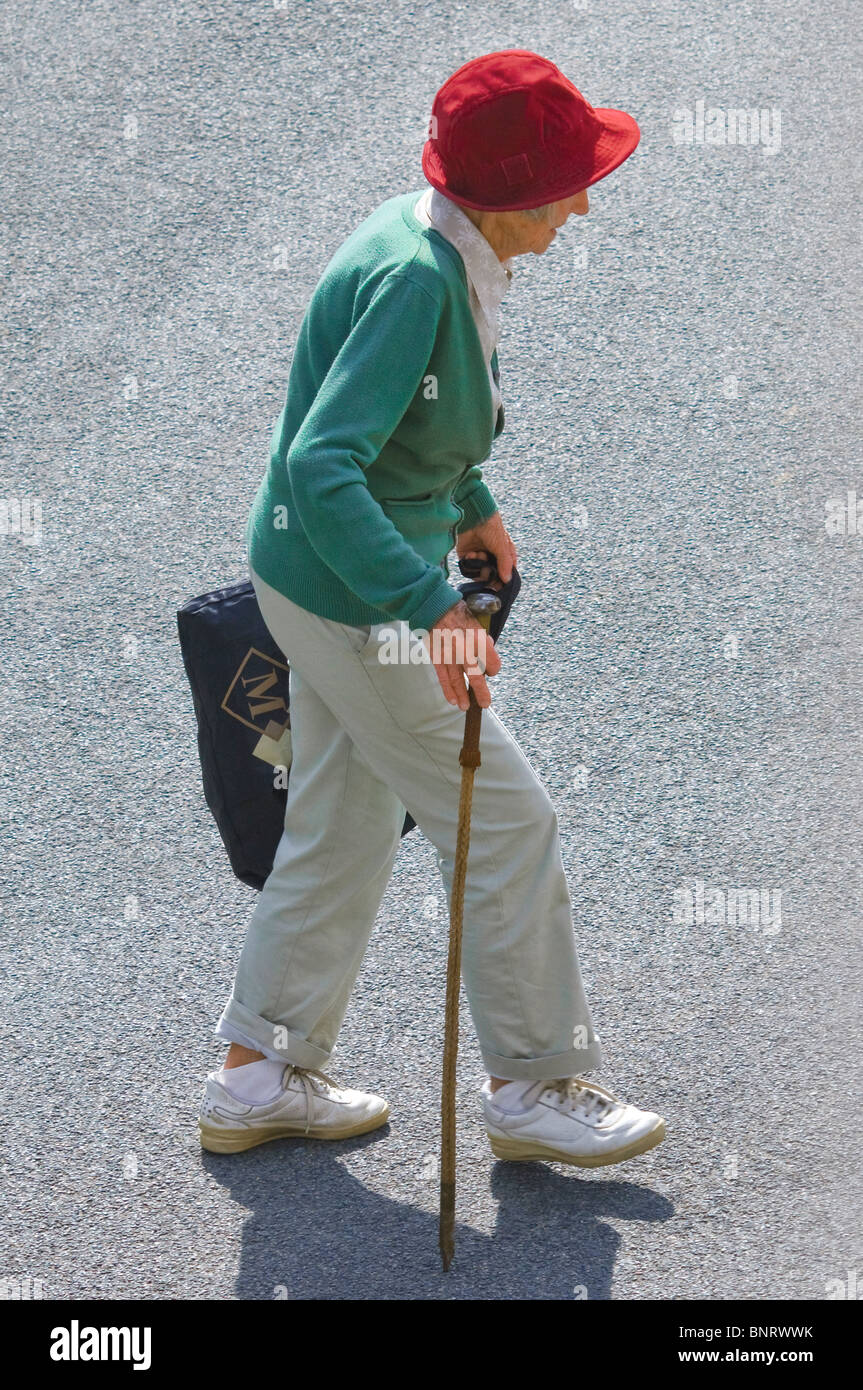 Femme âgée avec quelques malades crossing road - France. Banque D'Images