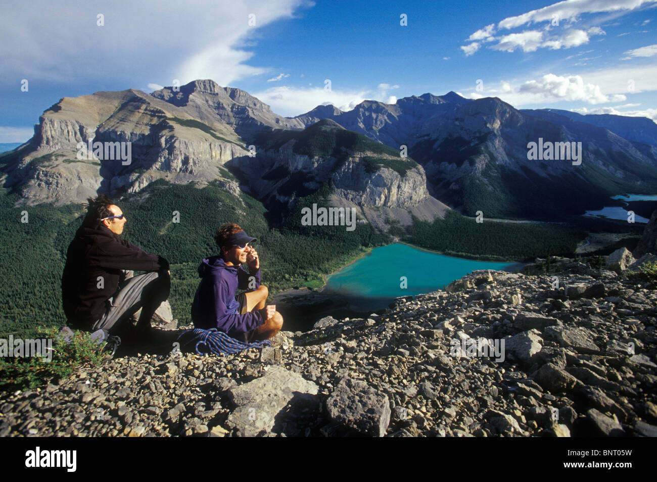 Deux alpinistes restez en contact en parlant sur un téléphone cellulaire dans les montagnes. Banque D'Images