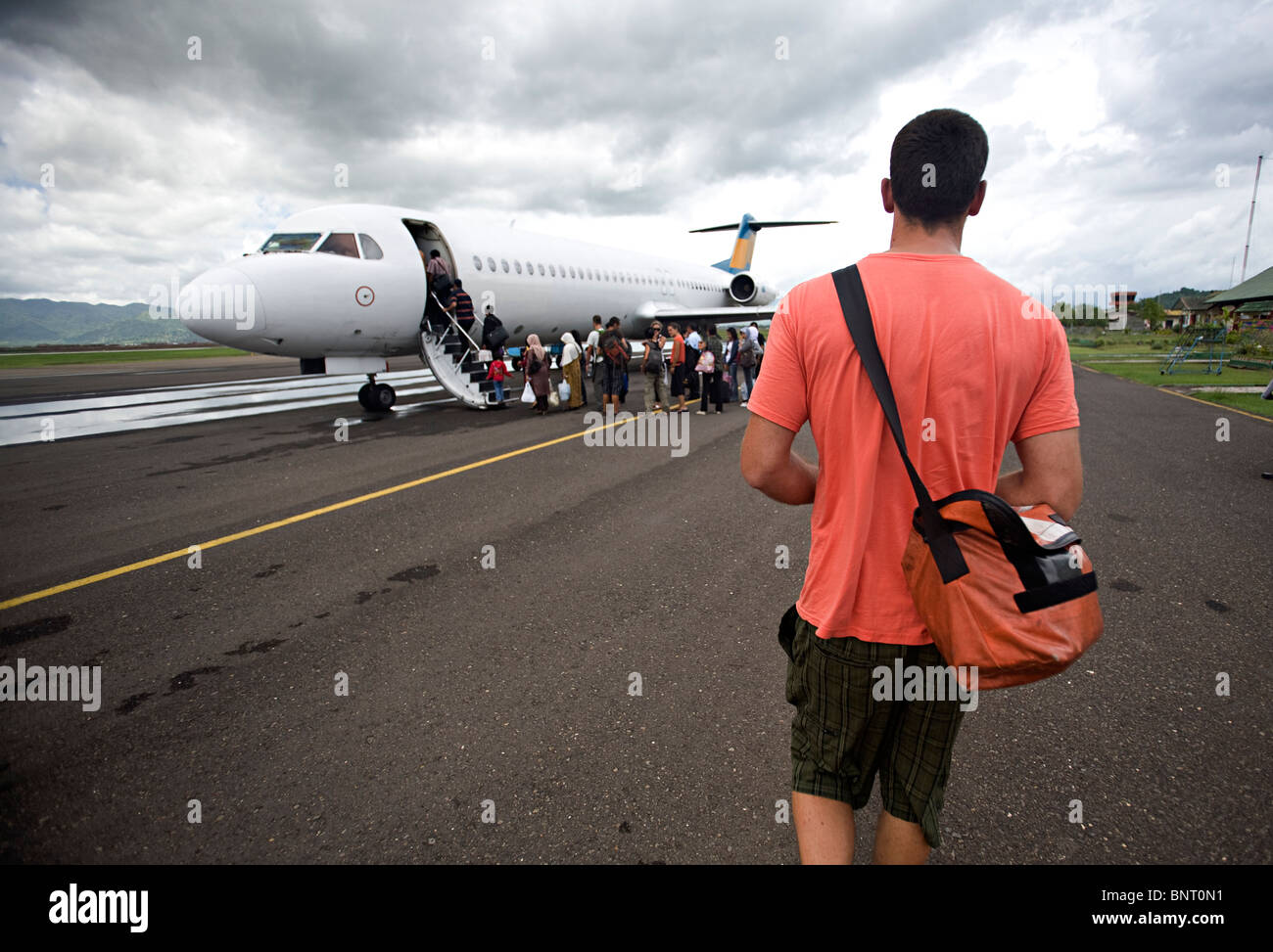 Homme de grande taille avec sac d'épaule se rend à l'avion. Banque D'Images Homme de grande taille avec sac d'épaule se rend à l'avion. Banque D'Images
