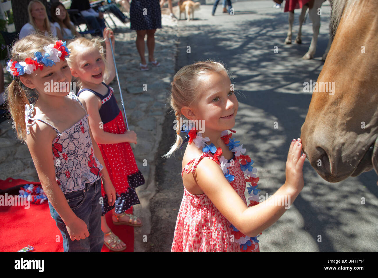 5-6 ans girl petting horse en Juillet 4ème jour de l'indépendance Parade. © Myrleen Pearson Banque D'Images