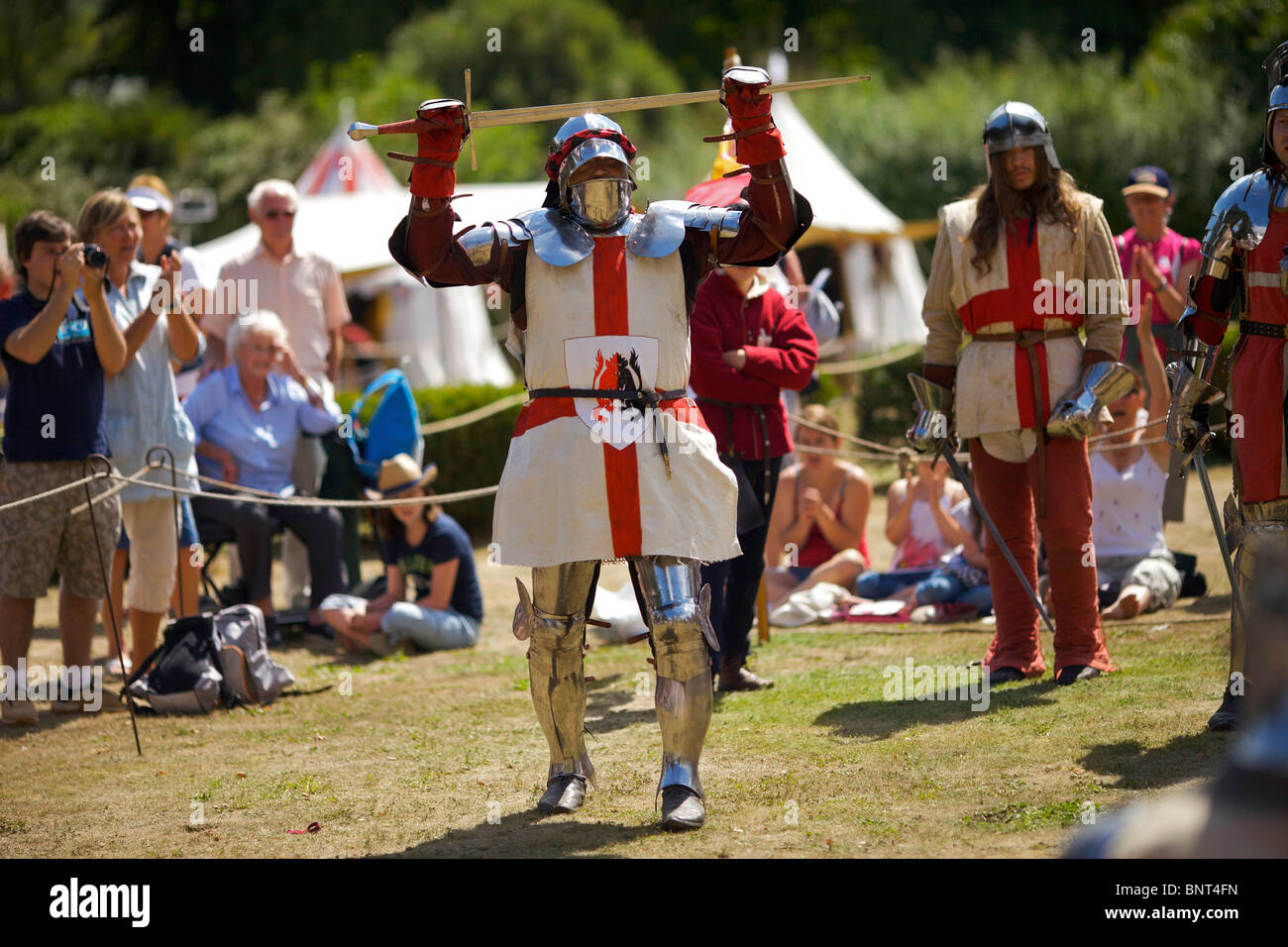 Habillé en armure authentique et à l'aide d'épées réel de reconstitution historique comme duel médiéval lors d'une fête médiévale qui a eu lieu à Arundel Banque D'Images