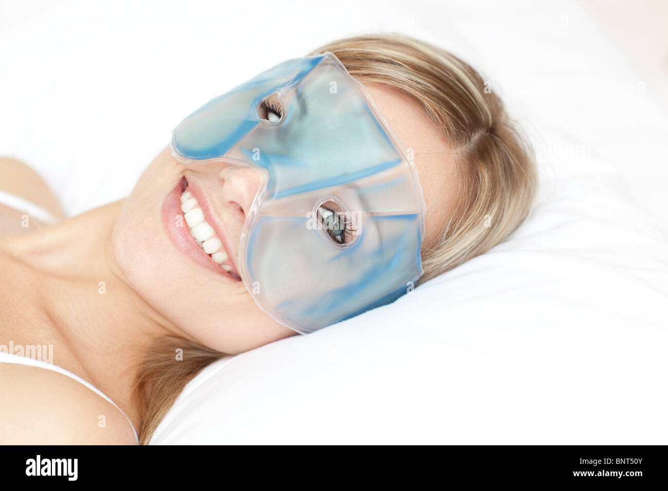Femme souriante avec un masque gel contour des yeux Banque D'Images