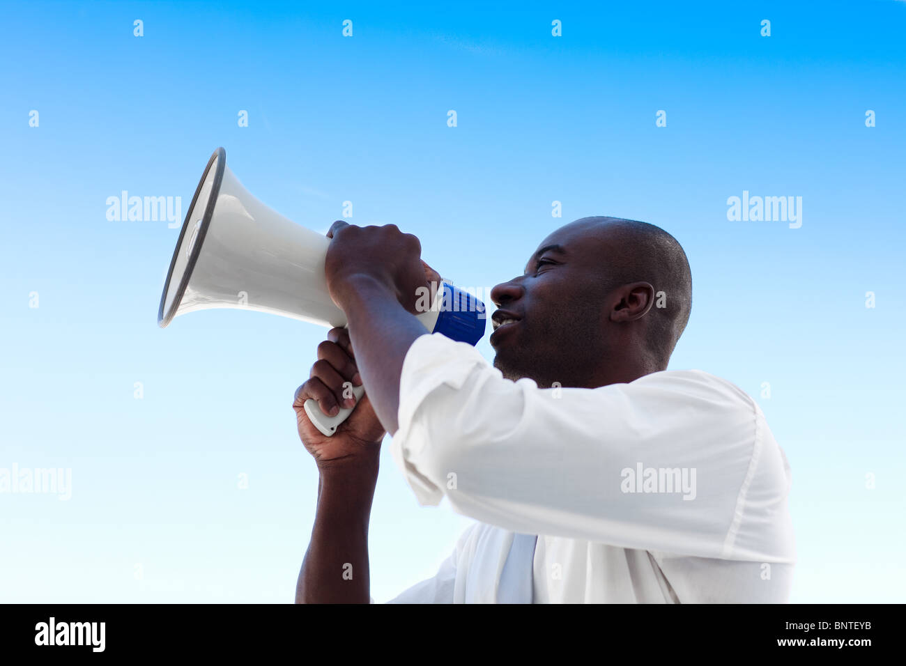 Angry businessman criant dans un mégaphone Banque D'Images